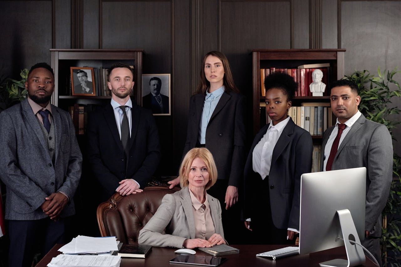 Services-01 Diverse group of professionals in corporate attire posing confidently in an office environment.