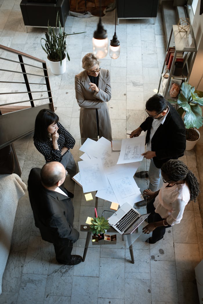 why-choose-us A team of professionals engage in a business meeting in a sleek, modern office setting.
